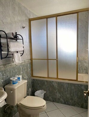 Un bagno con il water, un lavandino e un portasciugamani con asciugamani piegati.