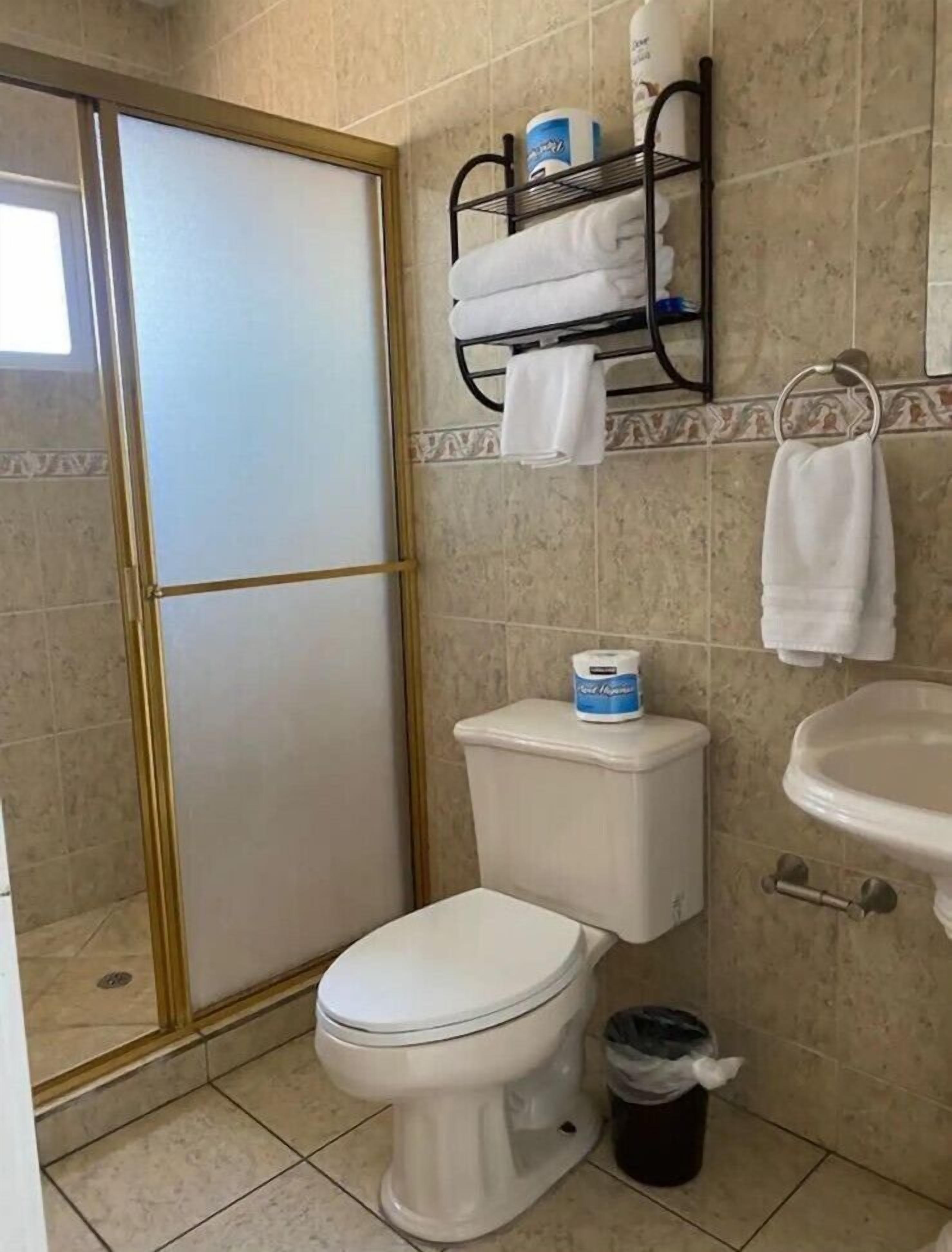 Un baño con inodoro, lavamanos y zona de ducha.