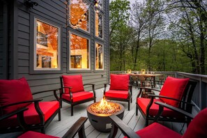 A deck with outdoor seating and a fire pit.
