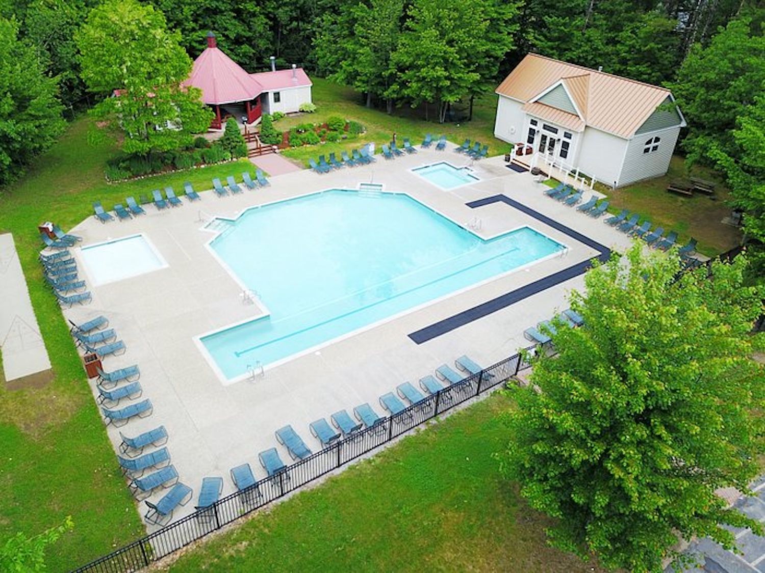 A swimming pool with lounge chairs and a small pavilion.
