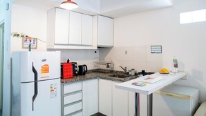 A modern kitchen with white cabinets, a built-in oven, a coffee maker, and a sink. - Charming studio in beautiful Buenos Aires with AC, WiFi (Buenos Aires)