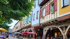 A street with outdoor seating and shops, including a clothing store.