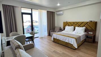 Suite superior, balcón, vista al mar | 1 habitación, caja de seguridad en la habitación y cortinas blackout