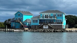 A waterfront property with two main buildings, a dock, and a rocky shoreline. - Charming Sound-front Captains Quarters in Frisco WiFi, streaming & perfect views (Frisco)
