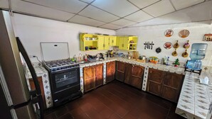 Una cocina con estufa a gas, horno, gabinetes amarillos y dispensador de agua.