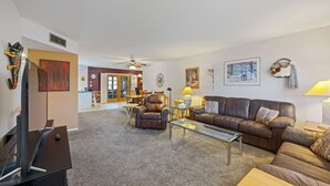 A spacious living room with a leather sofa, a coffee table, and a TV on a stand. - Pet-Friendly Sun City Retreat Near Golf & Shops (Sun City)