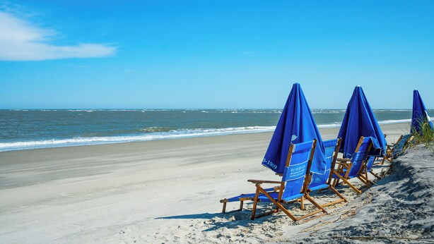 A beach with rows of blue beach chairs and umbrellas. - Stunning Ocean Views, Steps from Beach, Modern/Updated Condo- 302 Summerhouse (Isle Of Palms)