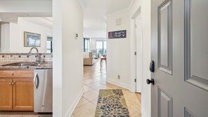 A hallway with a kitchen area, a dining area, and a living room. There is a sign indicating the room's coordinates. - Stunning Ocean Views, Steps from Beach, Modern/Updated Condo- 302 Summerhouse (Isle Of Palms)