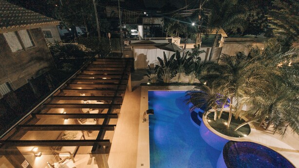 A rooftop pool with a wooden deck and a circular water feature. - JARDIM DO RIO SUÍTES (Florianopolis)
