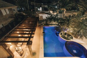 A rooftop pool with a wooden deck and a circular water feature. - JARDIM DO RIO SUÍTES (Florianopolis)