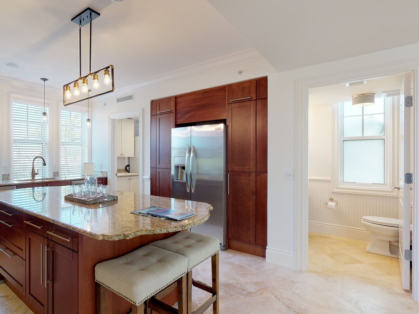 A modern kitchen with a central island, stainless steel appliances, and wooden cabinetry.