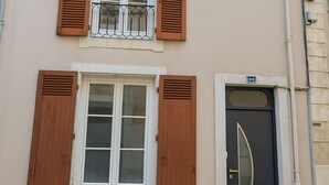 A building with two windows, a door, and a small balcony. - Cosy 5-bedroom townhouse. Close to all shops and hypercentre! (LE MANS)