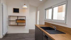 A modern kitchen with a wooden countertop, black sink, and pendant light. - Cosy 5-bedroom townhouse. Close to all shops and hypercentre! (LE MANS)