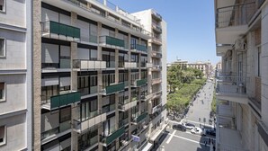 Un immeuble résidentiel à plusieurs étages, doté de balcons, donnant sur la rue et offrant une vue sur un ciel dégagé.