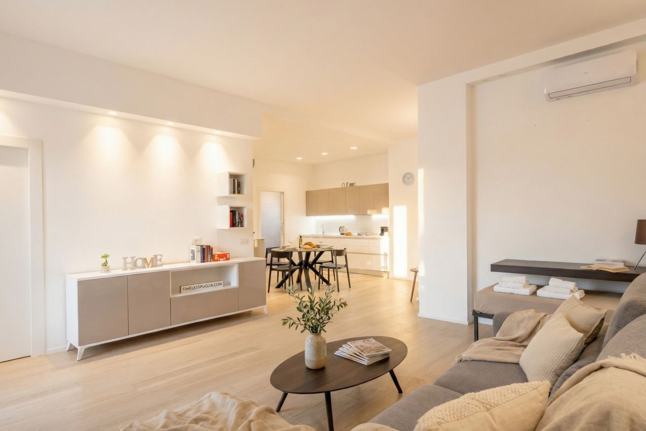 A modern living room with a sofa, a coffee table, and a dining area with a table and chairs.