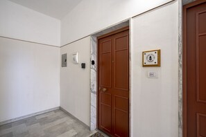 Un couloir avec un mur de marbre, une porte en bois et un panneau indiquant l’emplacement de la gare centrale.