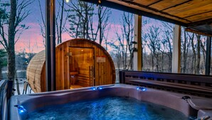 Un bain à remous avec un revêtement extérieur en bois et une vue sur une zone boisée.