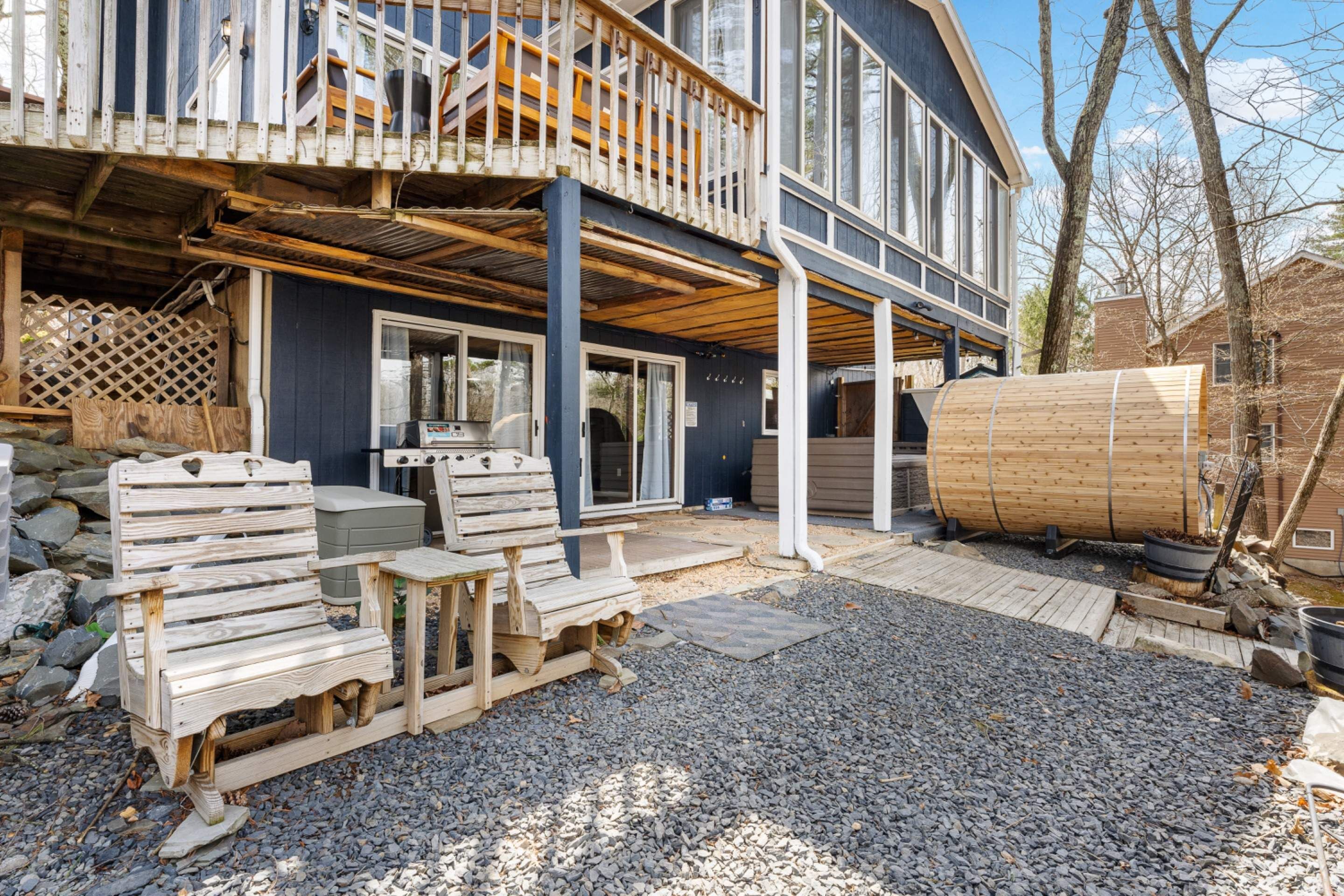 A two-story building with a wooden deck and a large barrel.