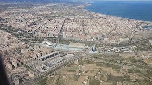 Une vue aérienne d’une ville avec un grand stade, des bâtiments environnants et une côte.