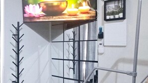 A television mounted on a wall displaying a serene scene with a bowl, candles, and flowers.