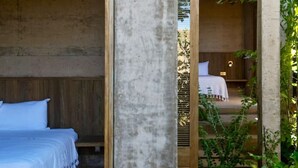 A modern, minimalist bedroom with a large bed and a small bedside table. - Casa NAYA 2 - Incl Full Service (Puerto Escondido)