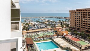 A resort with a swimming pool, a marina, and a view of the sea.