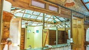 A wooden bathroom with two sinks, a large mirror, and a skylight. - Fare Manu (Moorea-Maiao)