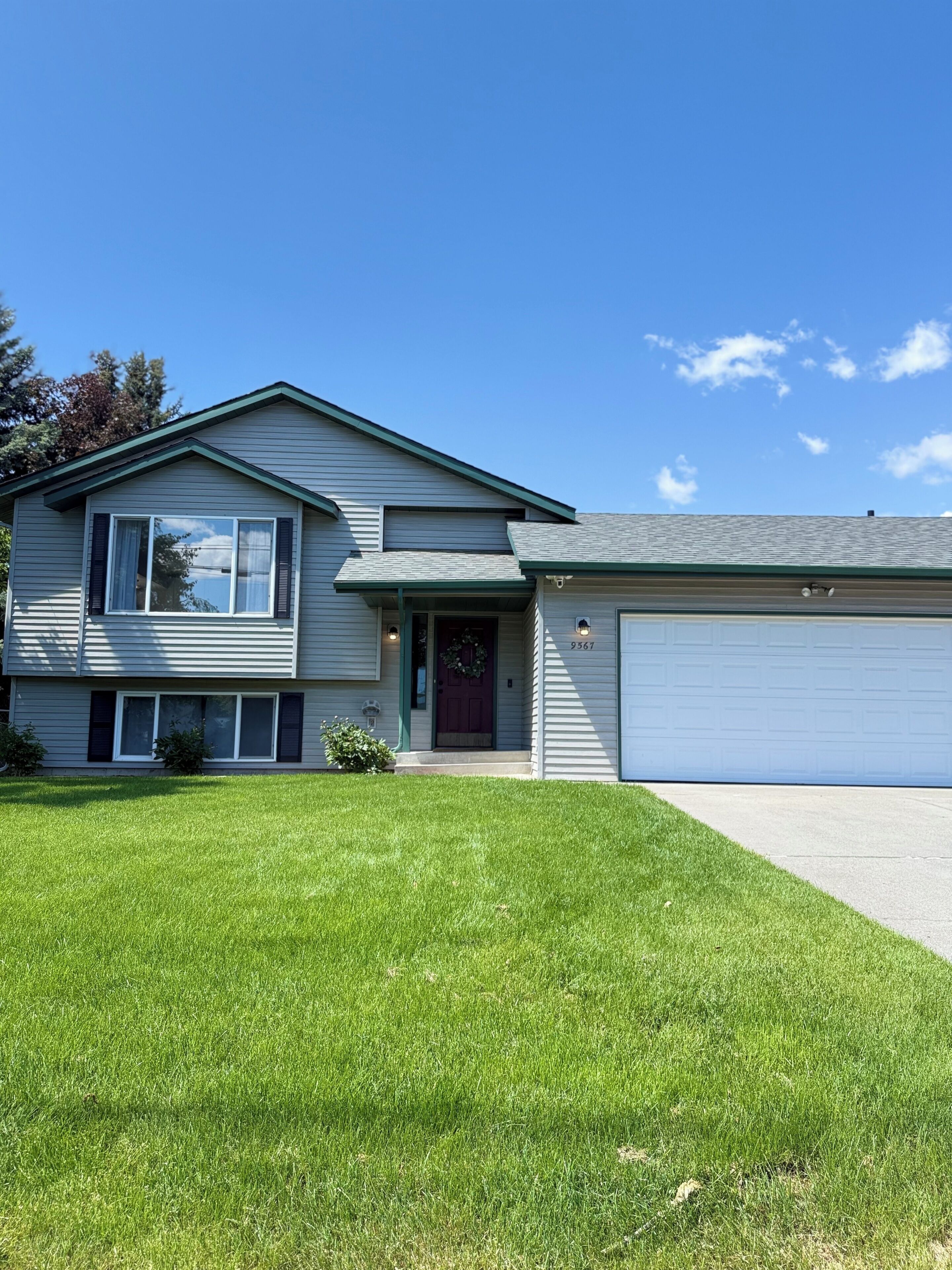 A two-story house with a garage, a well-maintained lawn, and a clear blue sky. - SILVERWOOD•Hot Tub•Lake Fun•Family Friendly•CLEAN! (Hayden)