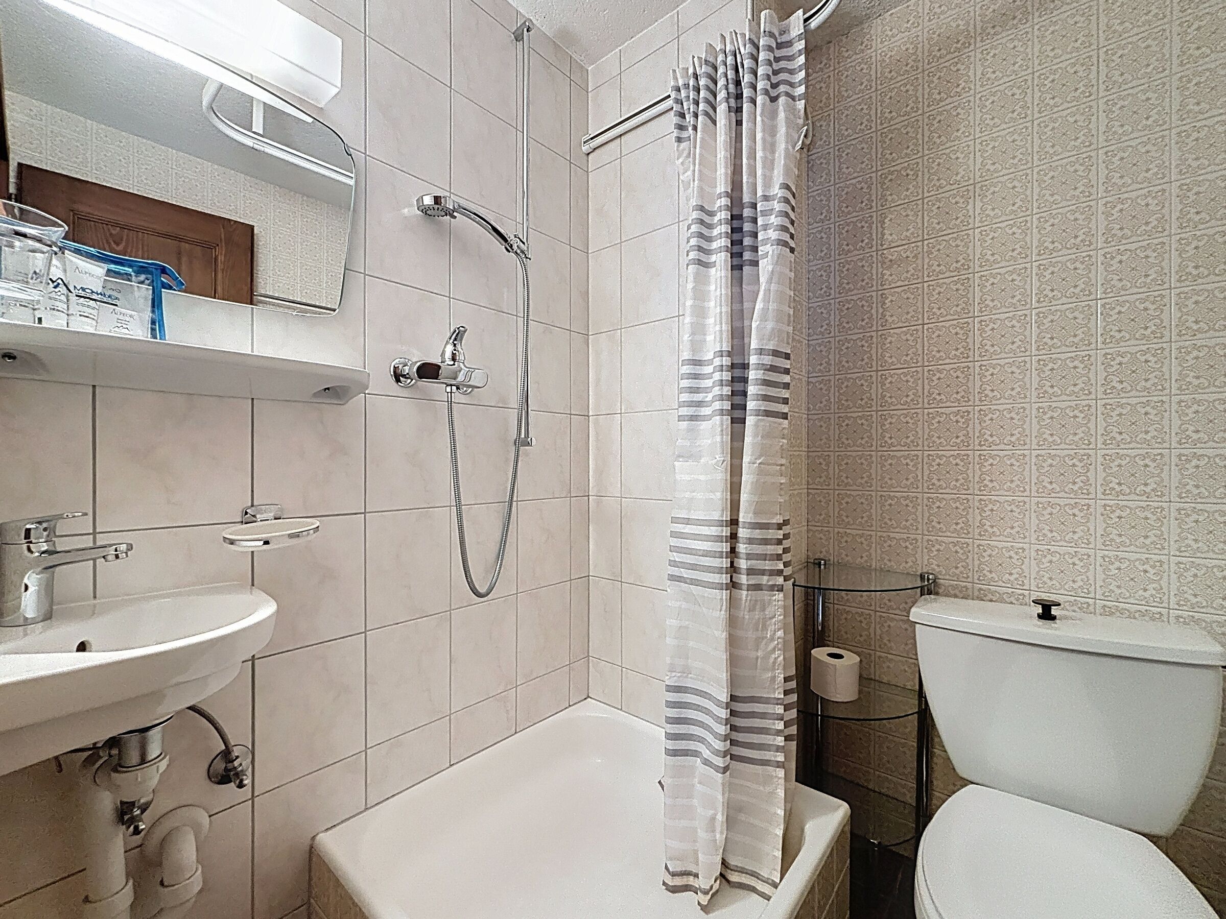 A bathroom with a shower, toilet, and sink.