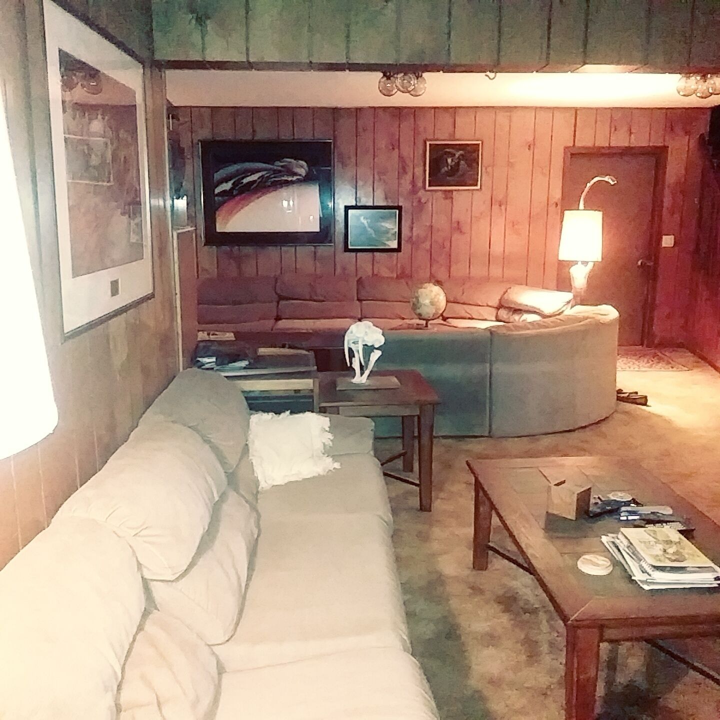Una sala de estar acogedora con un sofá, una mesita y un televisor montado en la pared.