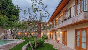 A modern hotel with a stone facade, a swimming pool, and a well-maintained garden. - Moã Charme Hotel (Mucuge)