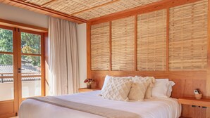 A spacious bedroom with a large bed, wooden ceiling, and a view of greenery outside. - Moã Charme Hotel (Mucuge)