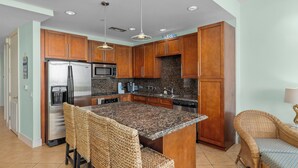 A modern kitchen with wooden cabinets, stainless steel appliances, and a granite countertop. - Sapphire Condominiums 406 - 3 bedroom, 2 bath, ***All reservations require a 72 hour notice*** (South Padre Island)