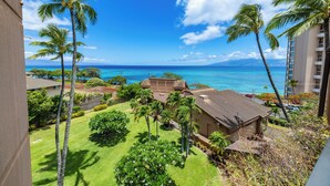 A view of a hotel with a lawn, palm trees, and a beach in the background. - Oceanview Kahana Villa - Walk to Beach & Dining (Lahaina)