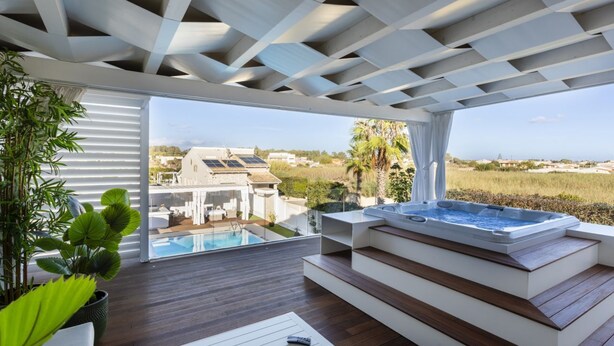 A modern outdoor hot tub area with a view of a house and pool. - Luxury Sea View Villa with Pool in Santa Maria del Focallo – Villa Barbara, Sici (Ispica)