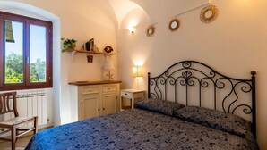 Une chambre à coucher avec un lit, une chaise, un bureau et une fenêtre.