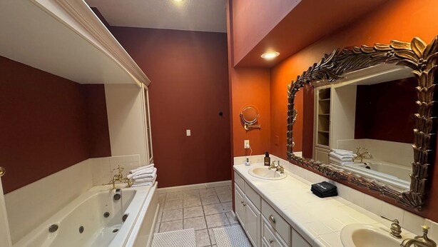 A bathroom with two sinks, a bathtub, and a large mirror with an ornate frame. - Downtown Yankton loft, perfect to gather, unwind, and create lasting memories. (Yankton)