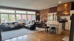 A spacious living area with a large sofa, a dining table, and a kitchen with a central island. - Downtown Yankton loft, perfect to gather, unwind, and create lasting memories. (Yankton)