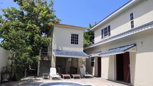 A two-story building with a swimming pool and outdoor seating area. - exotic beach & villa with WiFi, AC in tranquil Tower Isle with pool (Tower Isle)