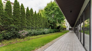 Un sentiero fiancheggiato da alberi e un edificio con ampie finestre.