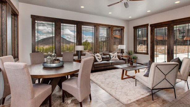 A spacious living area with a large dining table, comfortable seating, and a view of the mountains through large windows. - Steps to Cabriolet | Pool, Spa at Blackstone - Canyons Village Fun (Park City)