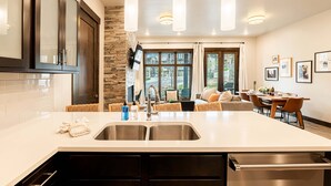 A modern kitchen with a large island, stainless steel appliances, and pendant lighting. - Steps to Cabriolet | Pool, Spa at Blackstone - Canyons Village Fun (Park City)