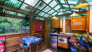 Una cocina compacta con muebles de madera, una mesa de comedor y un refrigerador pequeño.