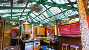 Una cocina compacta con armarios de madera, un lavamanos y una zona de comedor con una mesa.