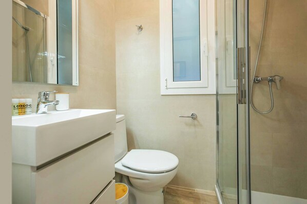 Un baño con inodoro, lavamanos y ducha.
