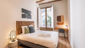 Une chambre à coucher avec un lit, une table de chevet et un bureau avec une chaise.