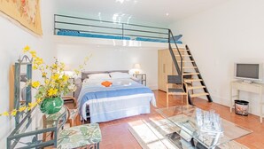 A modern bedroom with a bunk bed, a glass table with glasses, a TV, and a staircase. - La Maison de Marius - SAINT BONNET DE JOUX (SAINT BONNET DE JOUX)