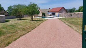 A gravel path leading to a pool area with a stone wall and a small building with a red roof. - La Maison de Marius - SAINT BONNET DE JOUX (SAINT BONNET DE JOUX)