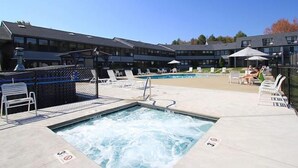 A pool area with lounge chairs, a hot tub, and a fenced swimming pool. - Spacious 2BR Townhouse with Full Kitchen (Wells)