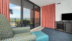 Ein Balkon mit einer Couch, einem Fernseher und Blick ins Freie.